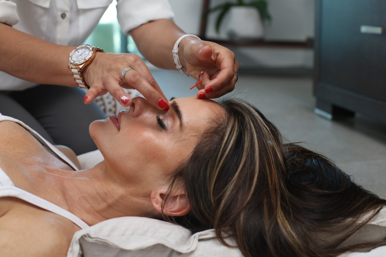Primer plano de un tratamiento facial en cabina, con la esteticista trabajando sobre la frente