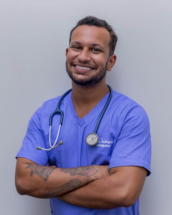 Veterinario con uniforme azul y fonendoscopio, de brazos cruzados
