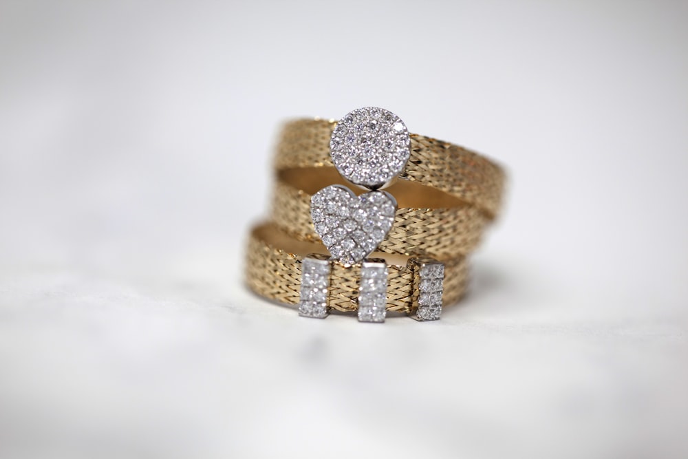 Tres anillos de oro con pavé de diamantes sobre mármol