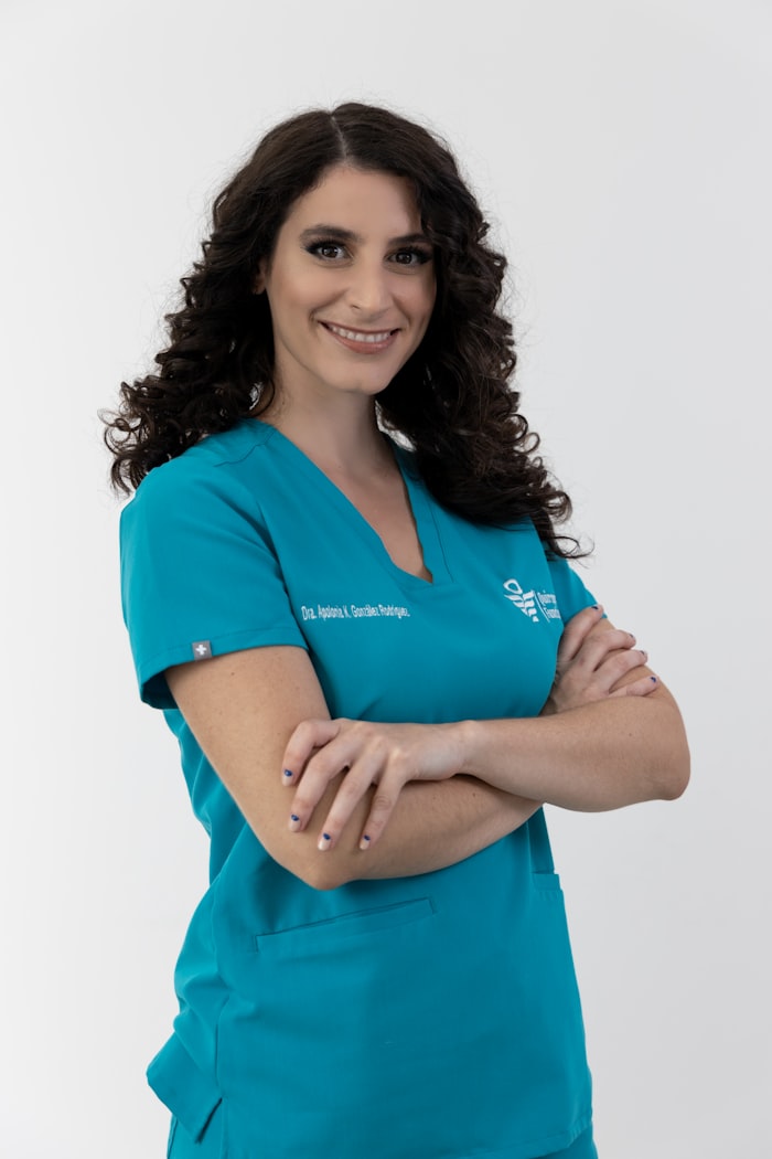 Médica con uniforme turquesa, retrato sobre fondo blanco